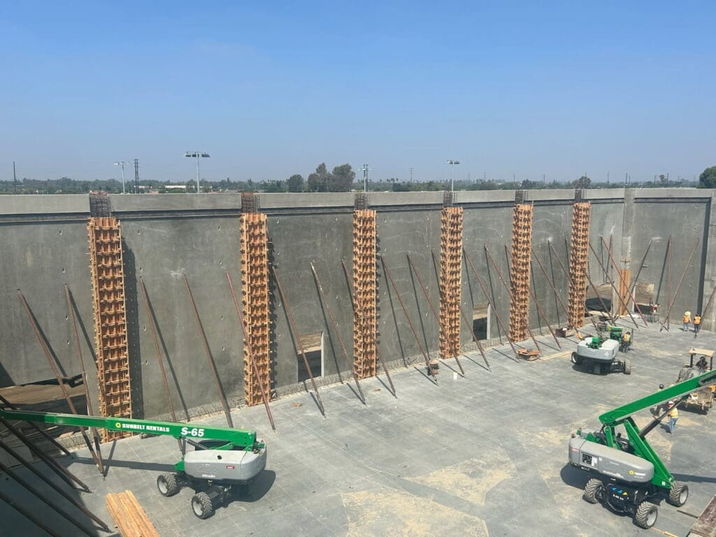 Construction site with cranes and wall supports.